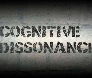 Cognitive,Dissonance,Stencil,Print,On,The,Grunge,White,Brick,Wall