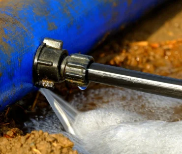 Water spraying from a leaking pipe fitting on a water line